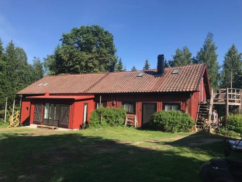 卡特琳娜霍尔姆Björnåsen Bear Hill的一座红色的房子,位于郁郁葱葱的绿色庭院上