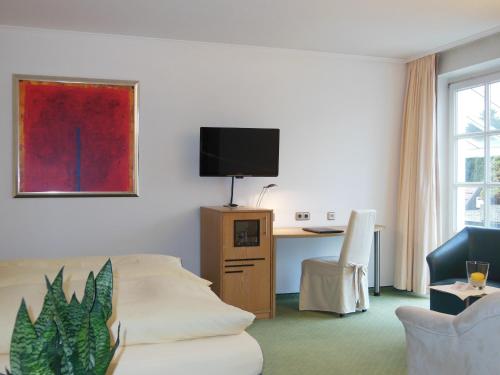 伊本比伦哈勃特斯诺夫酒店的客房设有沙发和带电视的书桌。