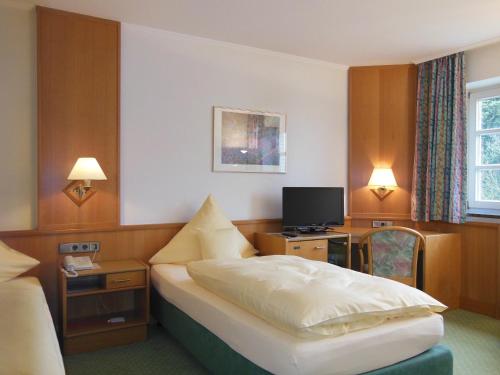伊本比伦哈勃特斯诺夫酒店的酒店客房,配有床和电视