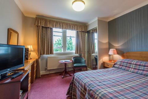 威廉堡亚历山大酒店的配有一张床和一台平面电视的酒店客房