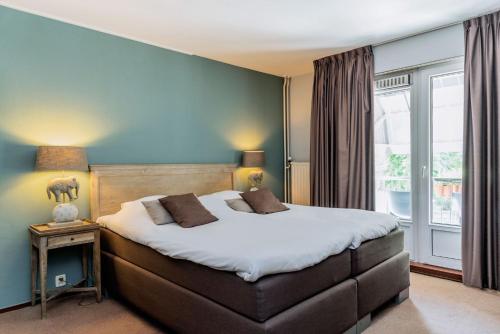 雷嫩亭园酒店的一间卧室设有一张大床和一个窗户。