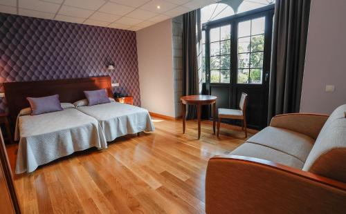 普拉维亚Hotel Rey Silo的酒店客房设有两张床和一张桌子。