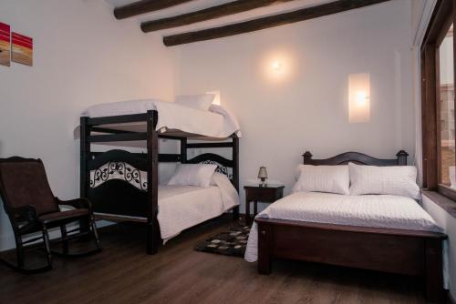 莱瓦镇Hospederia Flor de la Villa Real的一间卧室配有两张双层床和椅子