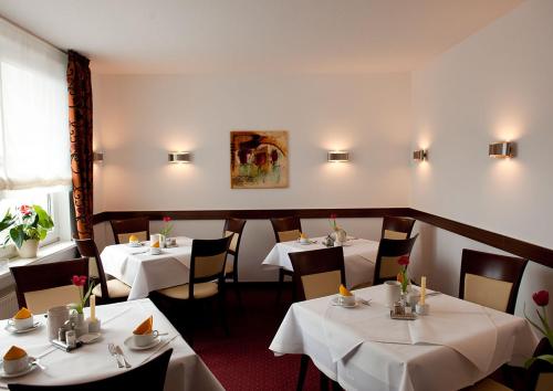 汉诺威豪斯斯帕库勒伽尼酒店的餐厅配有桌椅和白色桌布
