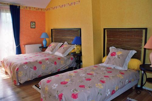 Futeaule four au bois的卧室设有两张床铺和橙色墙壁