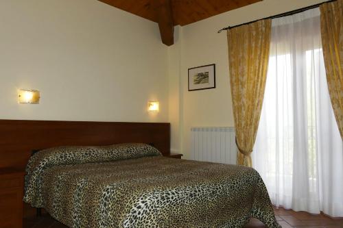 MonterubbianoVilla Montotto的一间卧室设有一张床和一个大窗户