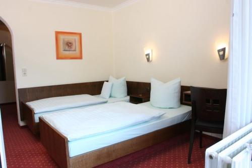 奥伊斯基兴罗特科普夫酒店餐厅的一间带两张床和椅子的房间