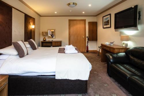 科尔朵凯尔恩道驿站马车旅馆的酒店客房设有一张大床和一张沙发。