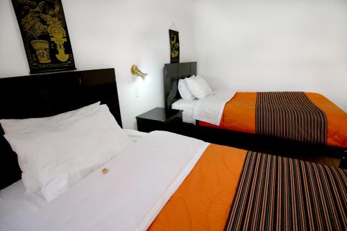 库斯科Hotel Peru Real的一间酒店客房,房间内设有两张床