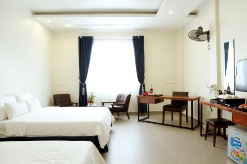 海防Noblesse Hotel的酒店客房配有两张床和一张书桌