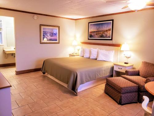 五月岬郡埃文代尔海洋酒店的配有一张床和一把椅子的酒店客房