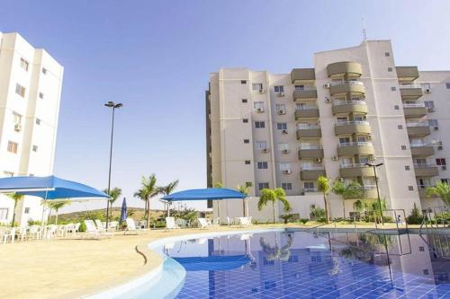 卡达斯诺瓦斯Lagoa Quente Flat Service的大楼前设有游泳池的酒店