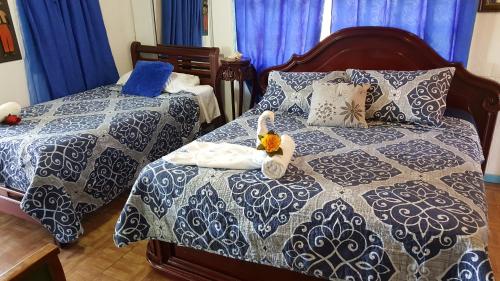 圣安德烈斯Posada Nativa Licy的一间卧室配有两张蓝色和白色的床
