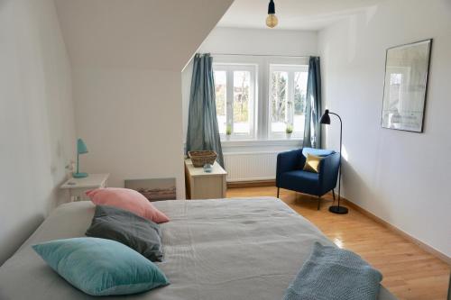 韦斯特兰Alter Konsumverein App N°9的一间卧室配有带枕头的床铺和蓝椅
