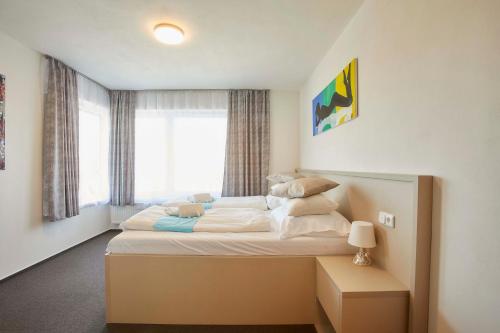 布尔诺拉克威酒店的一间卧室设有一张大床和窗户
