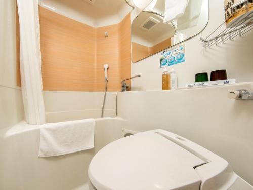 松本松本站前超级酒店的白色的浴室设有卫生间和浴缸。