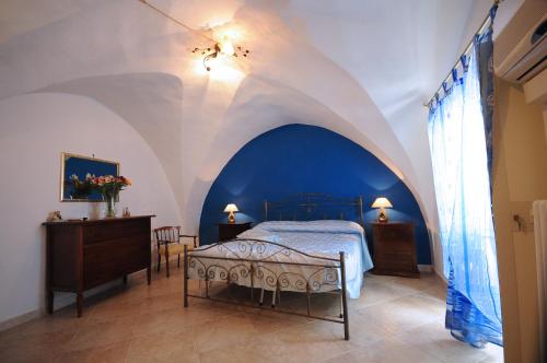 加利波利Palazzo Rocci Rooms的一间卧室设有一张床,拥有蓝色和白色的天花板