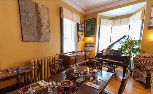 弗雷德里克顿卡瑞奇豪斯旅馆的客厅配有桌子和钢琴