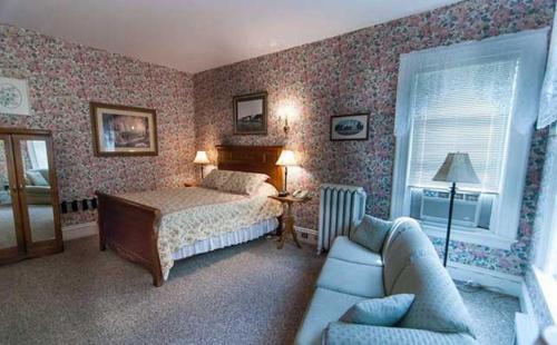 弗雷德里克顿卡瑞奇豪斯旅馆的一间卧室配有一张床和一张沙发