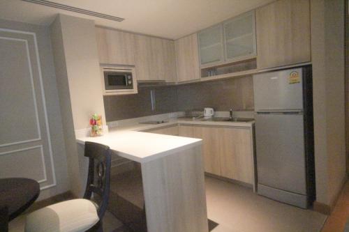 华欣Residence Nithiwat Amri Hua Hin的厨房配有白色的柜台和冰箱。