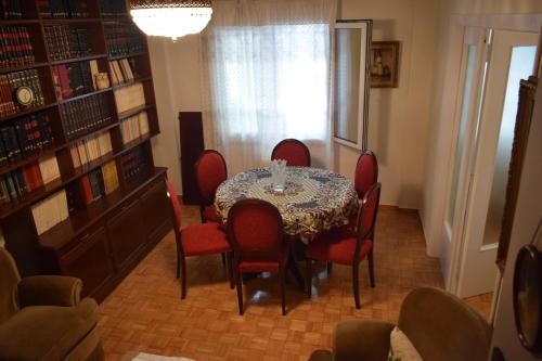 雅典George appartment的一间带桌子和红色椅子的用餐室