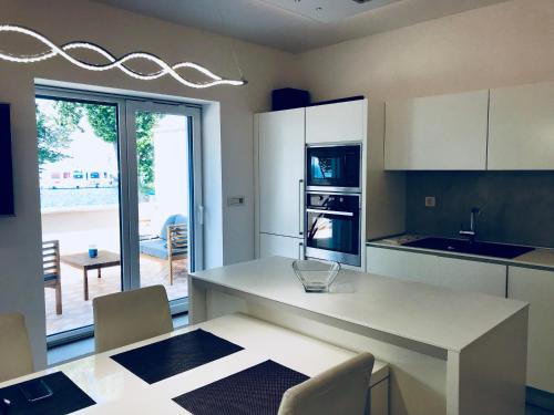 科佩尔Apartments & rooms Artemus Belveder的厨房配有白色橱柜和桌椅