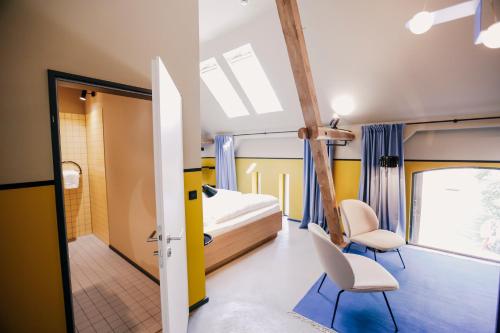 林特尔恩Hotel am Kloster - Domäne Möllenbeck的一间卧室,卧室内配有一张床和两把椅子