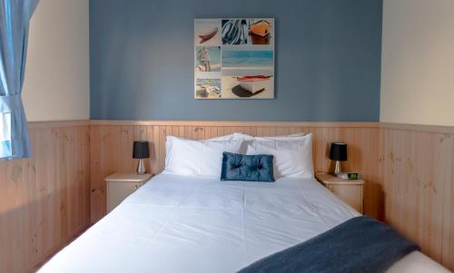 Potato Point海浪假日公园旅馆的卧室配有白色床和蓝色枕头