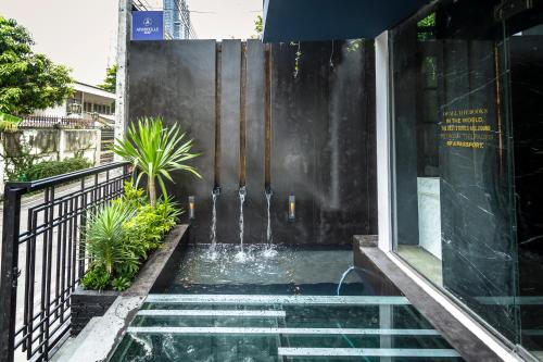 曼谷家图亚公寓酒店的一座建筑中间的游泳池,有一个喷泉