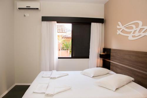 博西坎加拉里摩尔旅馆的一间卧室设有两张带白色床单的床和窗户。