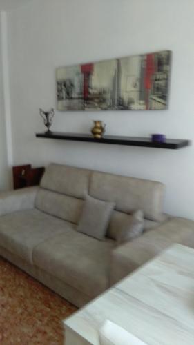 阿斯蒂Oasi di tranquillità的客厅配有沙发和墙上的架子