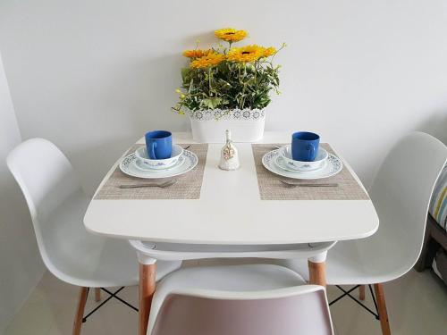 巴科洛德Cityscape Residences Unit 510的白色桌子,两杯,花瓶