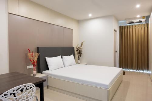曼谷DB Plus 5的卧室配有白色的床、桌子和椅子