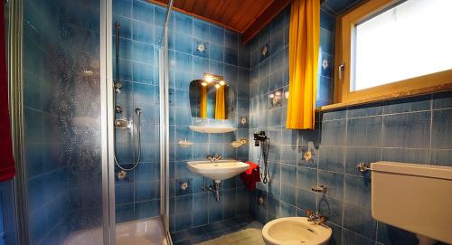 拉瓦莱Lüch da Spescia的蓝色瓷砖浴室设有水槽和卫生间