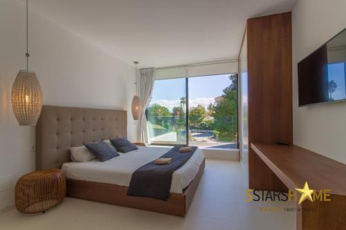 穆罗海滩Platja de Muro - 218324的一间卧室设有一张大床和一个大窗户