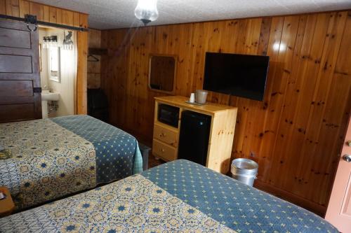 加特林堡Marshall's Creek Rest Motel的酒店客房设有两张床和一台平面电视。