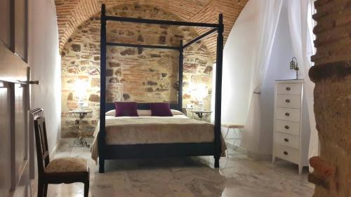卡塞雷斯DIANA JARDÍN的一间卧室设有一张床和砖墙