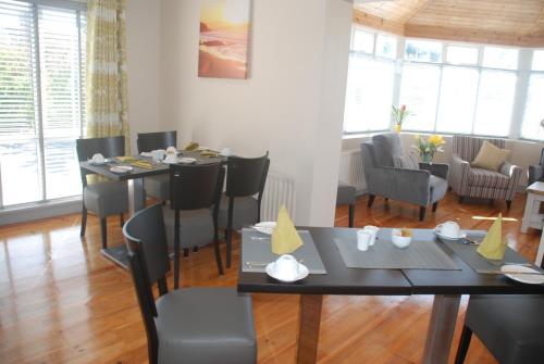 罗斯莱尔Tuskar House by the Sea的用餐室设有桌椅和窗户。