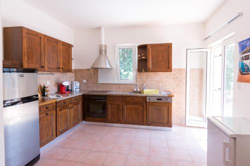 苏佩塔尔Apartment Supetar Blue Sky的厨房配有木制橱柜和白色冰箱。