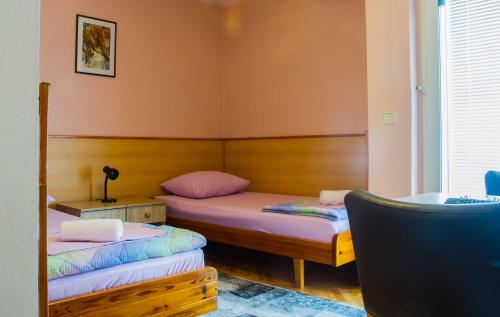 莫斯塔尔韩汽车旅馆的配有粉红色墙壁的客房内的两张床