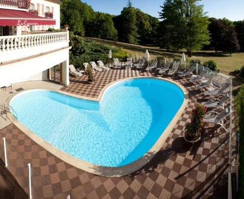 古维约夏多图尔酒店的享有带椅子的游泳池和大楼的顶部景致