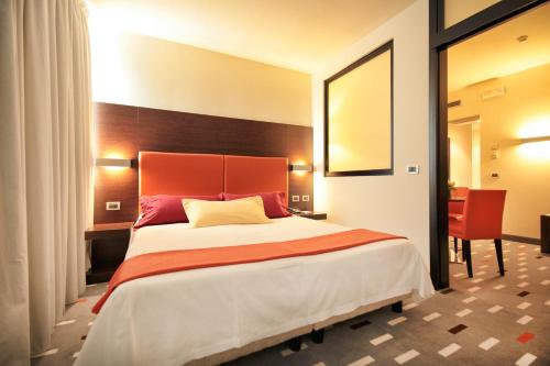 龙基德伊莱焦纳里梅杰酒店的一间卧室设有一张大床和红色床头板