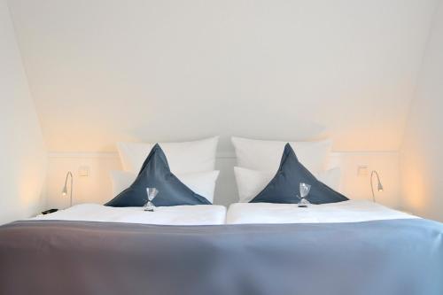 奥埃费努姆Rackmers Hof - Suiten Hotel garni mit Sauna的一张配有蓝色和白色枕头的大床