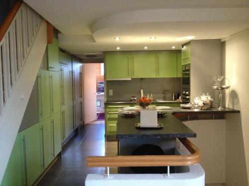 楚格Executive suite in Zug Old Town Triplex的厨房配有绿色橱柜和桌子