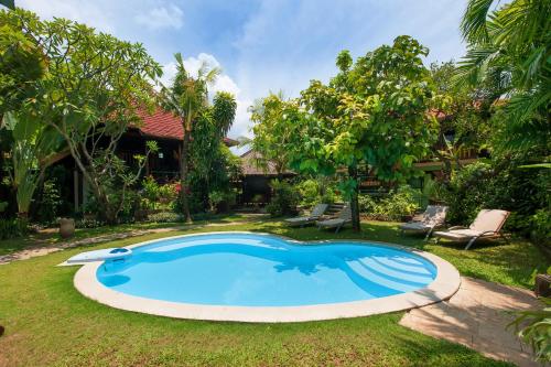 努沙杜瓦茅棚阿贡住宿加早餐旅馆的一座房子的院子内的游泳池