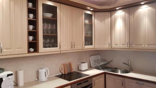 巴拉顿诺尔马迪Mimi Apartman的厨房配有白色橱柜和水槽