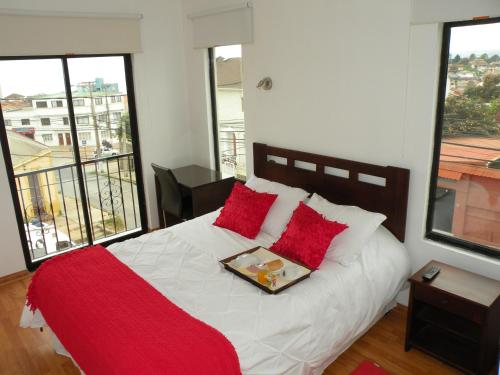 维纳德马B&B Hostel CasaMoro的一间卧室配有一张带红色枕头的床和托盘