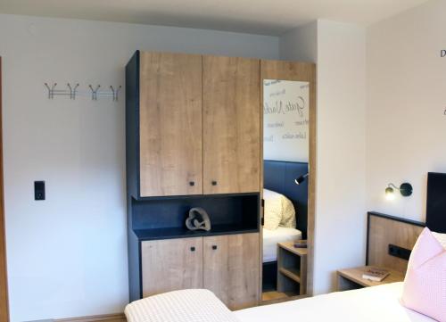 卡普尔Apart Riffla的一间卧室配有一张位于床边的大型木制橱柜