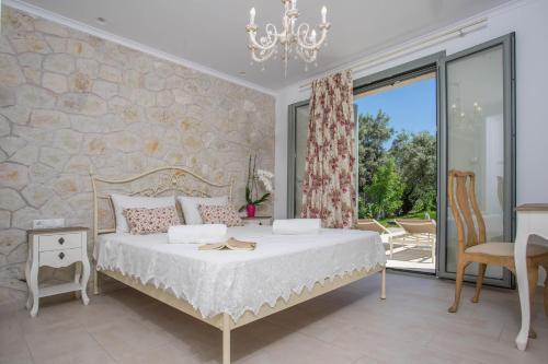 奈德里Alexandros Stone House的一间卧室设有一张床和一个大窗户