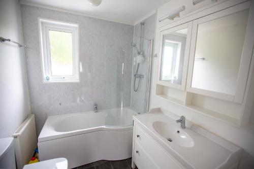 牛顿斯图尔特Kelpies Cottage的白色的浴室设有浴缸和水槽。